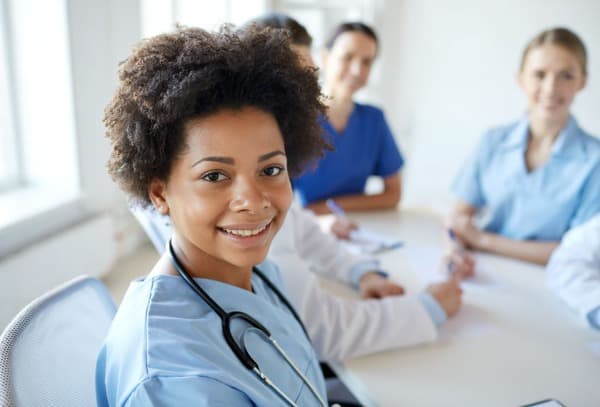 smiling-nurse-at-desk-with-co-workers