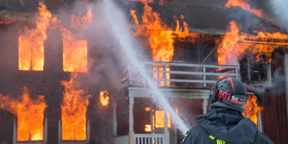 firefighter-putting-water-on-house-on-fire